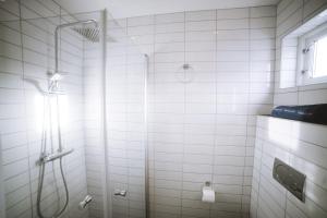 a white bathroom with a shower with a glass door at Fab scenery in Ballstad