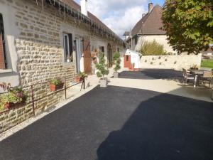 a courtyard of a building with a table and chairs at chambres d'hôte Le Marronnier in Champrougier