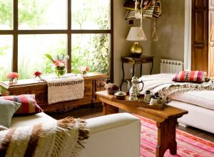 sala de estar con cama, mesa y ventana en House of Jasmines Relais & Châteaux en El Encón