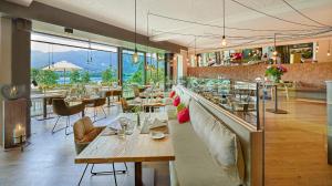 ein Restaurant mit einer langen Bar mit Tischen und Stühlen in der Unterkunft Kleines Hotel Kärnten in Egg am Faaker See