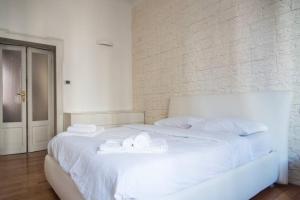 sypialnia z białym łóżkiem i ręcznikami w obiekcie YouHosty - Ranzoni 4 w Mediolanie