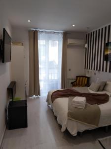 1 dormitorio con cama grande y ventana grande en Hostal Mendoza, en Madrid