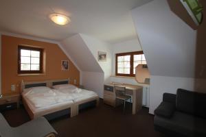 a small bedroom with a bed and a desk at Hostinec a penzion Dolní Dvůr in Veřovice