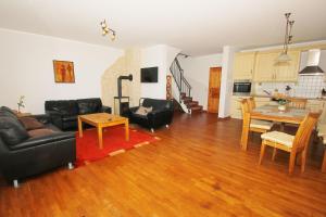 ein Wohnzimmer mit einer schwarzen Couch und einem Tisch in der Unterkunft Ostseehaus Odin Doppelhaushälfte in Wiek auf Rügen  + 17 Fotos