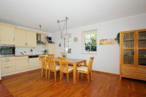 eine Küche mit Esstisch und Stühlen in der Unterkunft Ostseehaus Odin Doppelhaushälfte in Wiek auf Rügen 