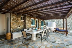 a dining room with a table and chairs at Sunset Villa Iza in Agios Ioannis Mykonos