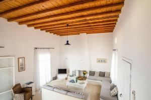 a living room with white walls and a wooden ceiling at Sunset Villa Iza in Agios Ioannis Mykonos