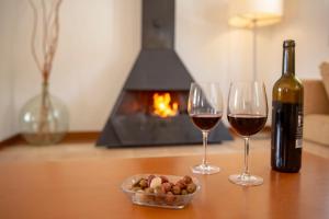 a table with two glasses of wine and a bowl of nuts at Finca Atalis - Adults Only in Santo Tomás