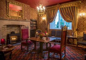 a living room with a fireplace and a table at Lough Rynn Castle in Mohill