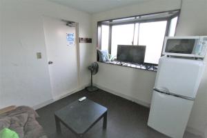 a living room with a refrigerator and a window at Edo Tokyo Hostel in Tokyo