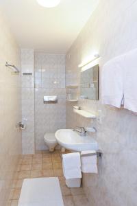 a white bathroom with a sink and a toilet at Haus Theresia in Mellau