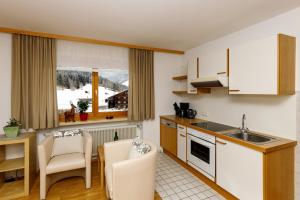a kitchen with white cabinets and a table and chairs at Haus Theresia in Mellau
