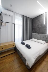 1 dormitorio con 1 cama grande con sábanas blancas en Royal apartment on Hmelnytskogo 37, en Leópolis