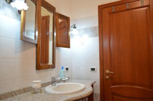 un bagno con lavandino e specchio di B&B Belvedere a SantʼAntìoco Altre 37 foto
