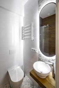 a white bathroom with a sink and a mirror at Royal apartment on Hmelnytskogo 37 in Lviv +15 photos