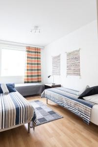 a bedroom with two beds and a couch at Two-Room Apartment Turku City Center host by B&B Tuure in Turku