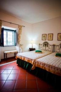 a bedroom with two beds and a window at Monte da Corte Ligeira in Cabeça Gorda