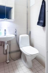 a white bathroom with a toilet and a sink at Two-Room Apartment Turku City Center host by B&B Tuure in Turku +7 photos