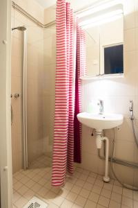 a bathroom with pink shower curtains and a sink at Two-Room Apartment Turku City Center in Turku