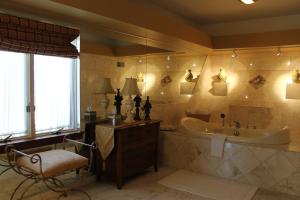 bagno con vasca, lavandino e sedia di Twin Pine Manor a Ephrata