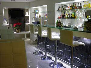 a bar in a restaurant with chairs and a counter at Epidavros Hotel in Athens