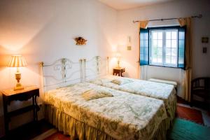1 dormitorio con cama y ventana en Monte da Corte Ligeira en Cabeça Gorda