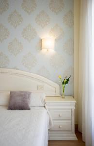 a bedroom with a white bed and a white dresser at Hotel Ciudad De Calahorra in Calahorra