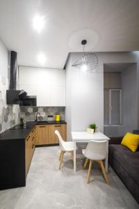 a kitchen and living room with a table and a couch at Royal apartment on Hmelnytskogo 37 in Lviv