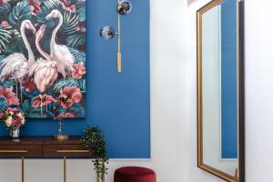 a room with a blue wall with a painting of flamingos at Stella Stays Gorgeous 5 BDR Palm Villa Beach Private Pool in Dubai