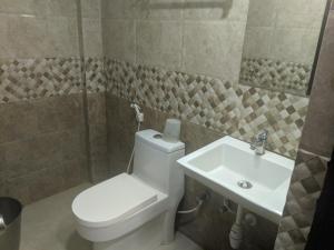 a bathroom with a toilet and a sink at Aashraya in Mysore