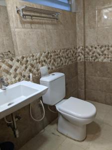 a bathroom with a toilet and a sink at Aashraya in Mysore