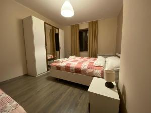 1 dormitorio con cama, mesa y espejo en Апартамент ИЦИ en Pleven
