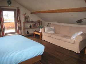 uma sala de estar com um sofá e uma cama em Vakantiehuis in de velden met zwemvijver en Jeu de Boules baan em Lier