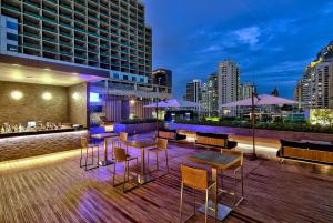 un bar en la azotea con mesas y sillas y un perfil urbano en Radisson Blu Plaza Bangkok en Bangkok