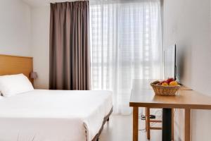 
a hotel room with a bed, table and window at Residhotel Galerie Tatry in Bordeaux
