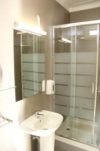 uma casa de banho com um lavatório e uma cabina de duche em vidro. em StayInn City - Évora em Évora