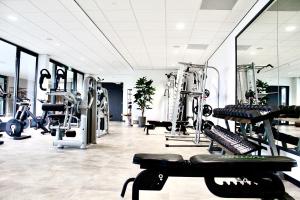 a gym with treadmills and machines in a room at Duinhotel Breezand in Vrouwenpolder