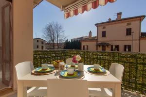 d'une table et de chaises blanches sur un balcon. dans l'établissement Appartamento Galileo - MyHo Casa, à Tortoreto Lido