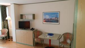 um quarto de hotel com uma pequena mesa e uma televisão em Aparthotel Rialto em Binz