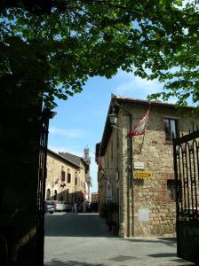 un viejo edificio de piedra con una bandera americana. en Angolo Alla Fortezza - Gigliola Contucci, en Montepulciano