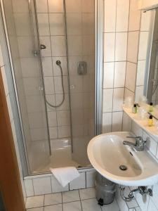 a bathroom with a shower and a sink at Motel Herbold in Knüllwald