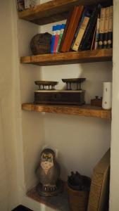 een boekenplank met een vaas en boeken erop bij Antica Dimora Rooms in Albisola Superiore