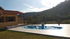 a swimming pool in a yard next to a house at Casa de campo in Petrópolis