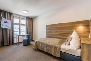 sypialnia z łóżkiem z drewnianym zagłówkiem w obiekcie Riemhofer Alter Schlachthof w Ratyzbonie