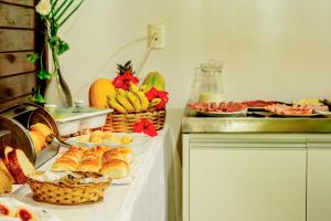 um buffet com pão e frutas sobre uma mesa em Pousada Lenda das Águas em Fernando de Noronha