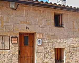ein Steingebäude mit einer Holztür und 2 Fenstern in der Unterkunft Casa La Catalina II in Beceite