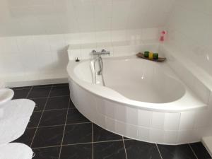 a white bath tub in a white tiled bathroom at BS Business Travelling in Hannover