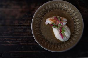 a bowl of food on a wooden table at Fab scenery in Ballstad