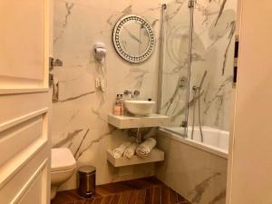 La salle de bains est pourvue d'un lavabo et d'une horloge murale. dans l'établissement Apartmenty Mariacka 20 -Self Check-In 24h -Loud on the weekends - by Kanclerz Investment, à Katowice 44 autres photos