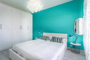 ein Schlafzimmer mit einem weißen Bett und einer blauen Wand in der Unterkunft Casa di Annika - Vista Laguna e Parcheggio privato in Grado